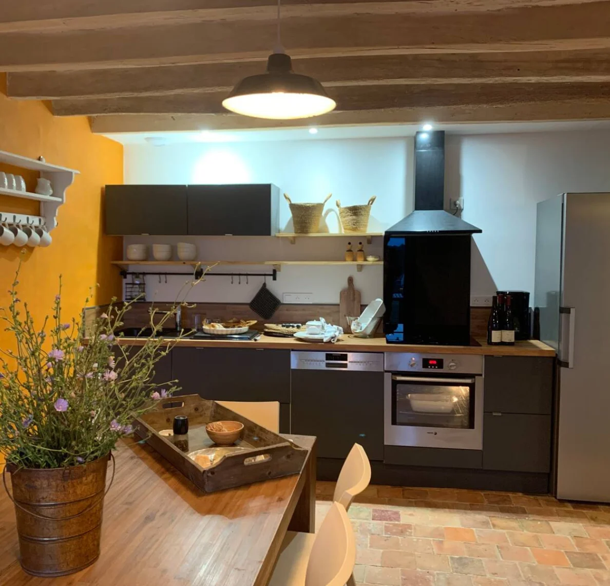 Cuisine entièrement équipée avec four, réfrigérateur, lave-vaisselle et coin repas.